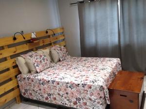 a bedroom with a bed with a wooden headboard at ASAMé @ Oppi-Rivier in Christiana