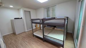 a room with three bunk beds in a room at Welcome Busan Guesthouse in Busan