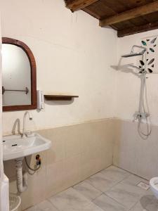 a bathroom with a sink and a mirror at Tropinest bungalows & hostel in Nungwi