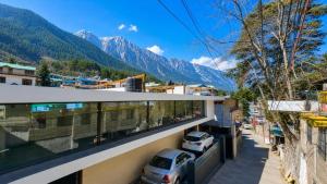 a building with a balcony with mountains in the background at Naini Hill View Boho in Nainital