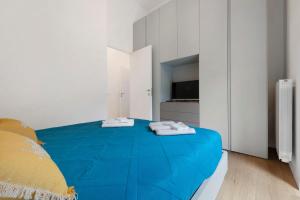 a bedroom with a blue bed and a television at Casa Vacanze Regina in Lecco