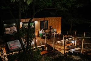two people sitting on the deck of a tiny house at Feelmore Tiny House Karancsalja in Karancsalja