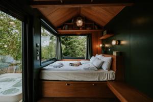 a small bedroom with a bed with a window at Feelmore Tiny House Karancsalja in Karancsalja