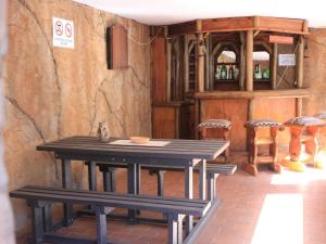 a table and stools in a room with a shelf of wine bottles at El Palmar Guesthouse in Groblersdal