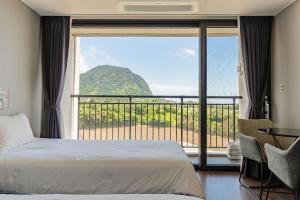 a bedroom with a bed and a view of a mountain at Sanbangsan Hotel in Seogwipo