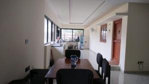 a dining room with a table and chairs and a kitchen at Peony By Dhiya in Jadgenhalli