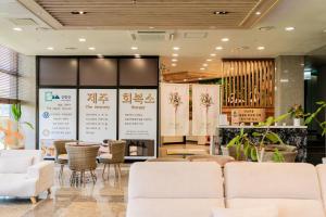 a lobby with white couches and chairs at Sanbangsan Hotel in Seogwipo +243 photos