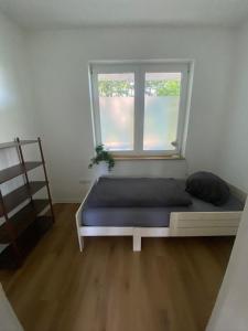 a bed in a room with a window at Wohnung nah der Weser Monteurenwohnung Ferienwohnung in Hoya