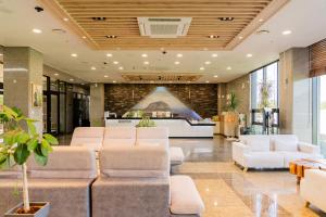 a lobby with white couches and a bar at Sanbangsan Hotel in Seogwipo