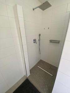 a shower with a glass door and a tile floor at Wohnung nah der Weser Monteurenwohnung Ferienwohnung in Hoya +5 photos