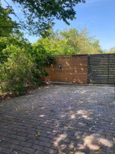 a brick parking lot with a fence and trees at Wohnung nah der Weser Monteurenwohnung Ferienwohnung in Hoya