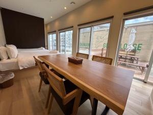 a room with a wooden table and a bed and a bedroom at OKINAWA GREEN LODGE in Okinawa City
