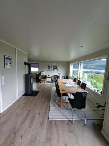 a dining room with a table and chairs and a fireplace at Koselig hus med flott utsikt in Vossevangen