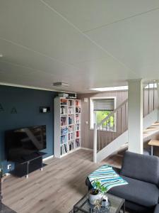 a living room with a couch and a tv at Koselig hus med flott utsikt in Vossevangen