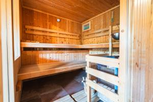 a wooden sauna with wooden benches in a room at Posestvo Laz - The Laz Estate in Voglarji