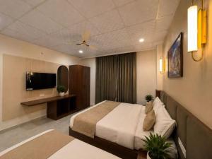 a hotel room with a bed and a television at Hotel kalyan near by Delhi igi airport free Pickup in Etāwah