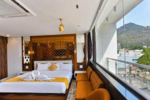 a bedroom with two beds and a balcony at Sara Happy Stay Hotel in Tiruvannāmalai