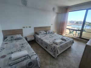 a bedroom with two beds and a balcony with a view at Tangra Guest House in Arapya