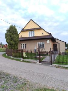 a house with a fence in front of it at Sielankowy Domek in Istebna