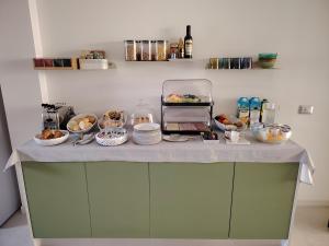 a counter with plates and bowls of food on it at B&B El Rocol in Garda
