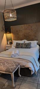 a bedroom with a large bed and a chandelier at Net 'n Bed in Middelburg