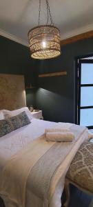 a bedroom with a bed and a chandelier at Net 'n Bed in Middelburg +6 photos