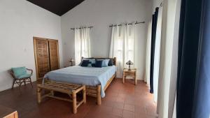 a bedroom with a bed and a chair and windows at YAI Wellness Oasis in Yallahs