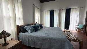 a bedroom with a large bed with blue pillows at YAI Wellness Oasis in Yallahs
