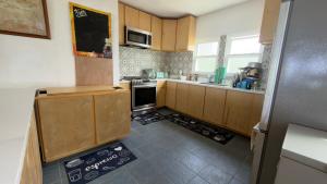 a small kitchen with wooden cabinets and a refrigerator at YAI Wellness Oasis in Yallahs