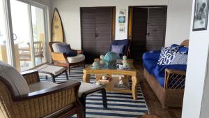 a living room with a blue couch and a surfboard at YAI Wellness Oasis in Yallahs