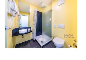 a bathroom with a shower and a toilet and a sink at Hostel Art & Style in Singen +30 photos