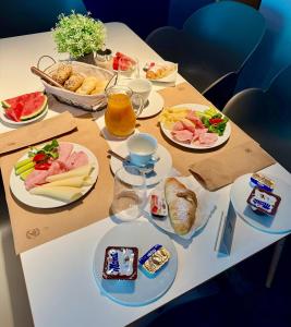 a table with plates of food and drinks on it at Pension Milk Inn in Prague