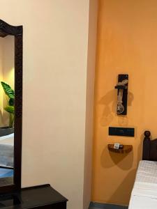a bedroom with a mirror and a phone on the wall at Rasa Homestay in Dickwella +4 photos