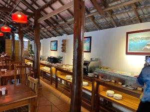 a dining room with wooden tables and a restaurant at La Mer Resort, Phú Quốc in Phú Quốc