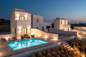 a villa with a swimming pool at night at Eupnoia Villas in Agios Arsenios
