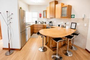 a kitchen with a wooden table and a refrigerator at Jetty Seaview Apartment in Swakopmund