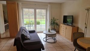 a living room with a couch and a tv and a table at Residenz Moselstausee in Sankt Aldegund