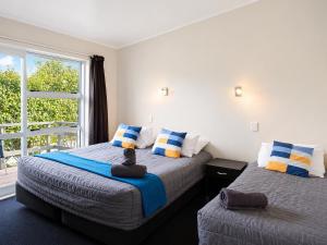 a bedroom with two beds and a window at Taupo Debretts Spa Resort in Taupo +102 photos