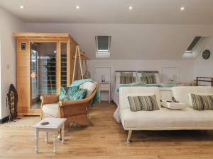 a living room with two white couches and a bed at The Retreat in Goole