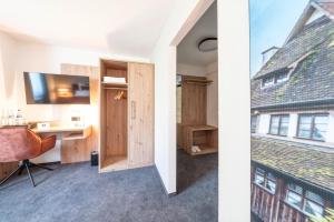 two images of a room with a desk and a window at Krone 1516 in Elchingen +63 photos