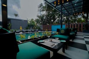 a patio with a table and chairs and a swimming pool at King's Mansion in Candolim