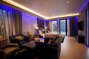 a living room with purple lighting in a hotel room at King's Mansion in Candolim