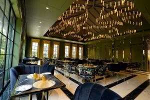 a restaurant with tables and chairs and a large chandelier at King's Mansion in Candolim