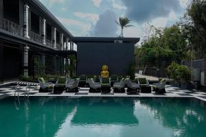 a pool with chairs and a fountain in a building at King's Mansion in Candolim