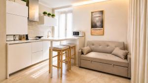 a kitchen with a couch and a table in a room at Lecco Antico Pozzo - Modern Suite in Lecco