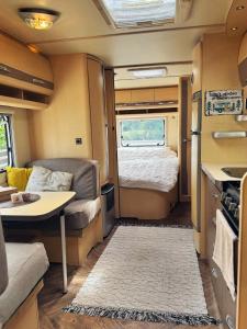 a small caravan with a bed and a small kitchen at Caravana dintre nuci in Oradea