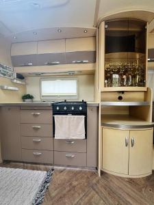 a kitchen with a stove and cabinets and a sink at Caravana dintre nuci in Oradea +15 photos