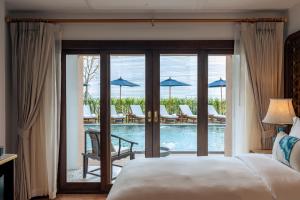 a bedroom with a bed and a view of a pool at CHINO@NIMMAN Luxury Boutique Hotel in Chiang Mai