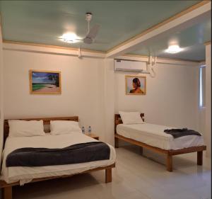 a bedroom with two beds and a ceiling at Gk Eleven in Himmafushi +17 photos