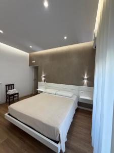 a bedroom with a large white bed and a chair at B&B Ciocca II in Campobasso
